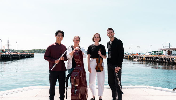 Musikere stilt opp med vann i bakgrunnen